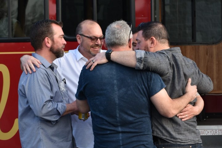 a group of people standing in front of a bus